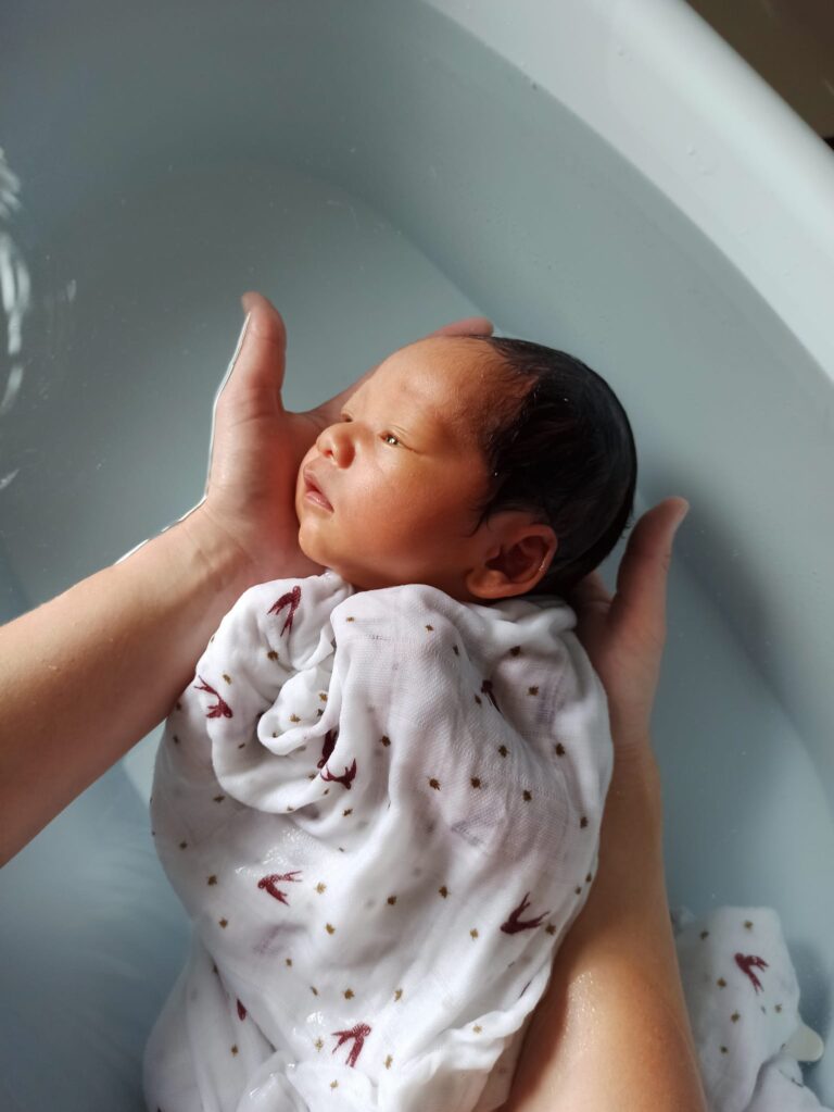 Nouveau-né emmailloté pendant son bain thérapeutique