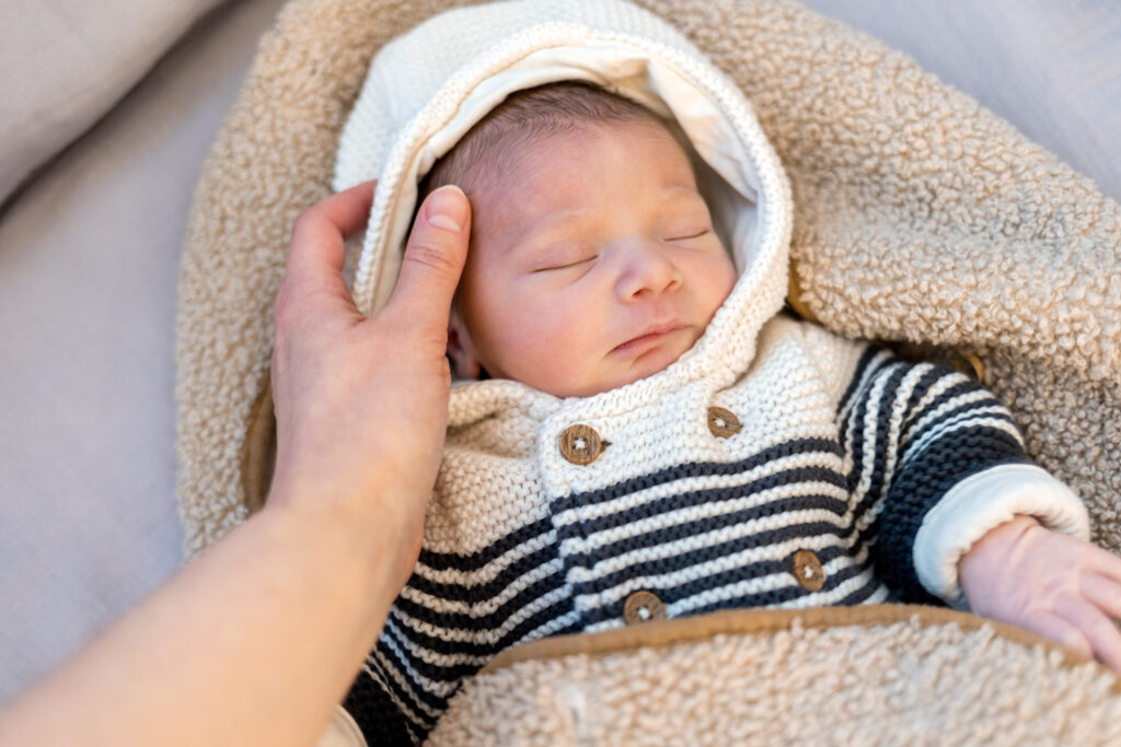 Main caressant le visage d'un nouveau-né endormi